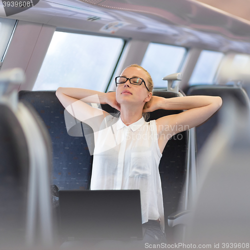 Image of Woman streching while travelling by train.