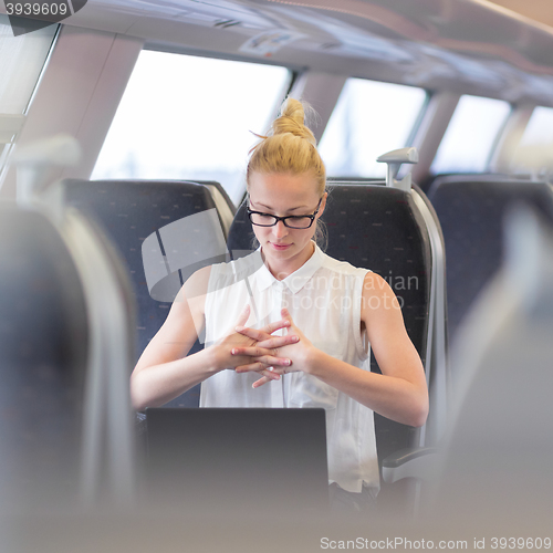 Image of Woman streching while travelling by train.