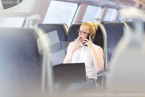 Image of Business woman working while travelling by train.