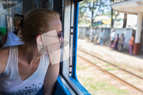 Image of Young female adventurer traveling by train in Asia.