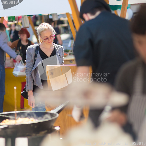 Image of Woman buying meal at street food festival.