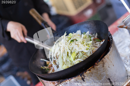 Image of Cheff cooking on outdoor street food festival.