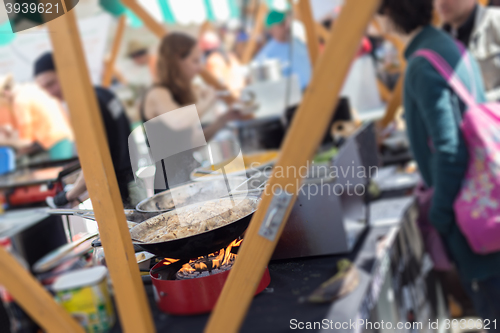 Image of Cheff cooking on outdoor street food festival.