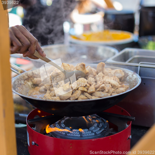 Image of Cheff cooking on outdoor street food festival.