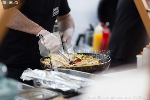 Image of Cheff cooking on outdoor street food festival.