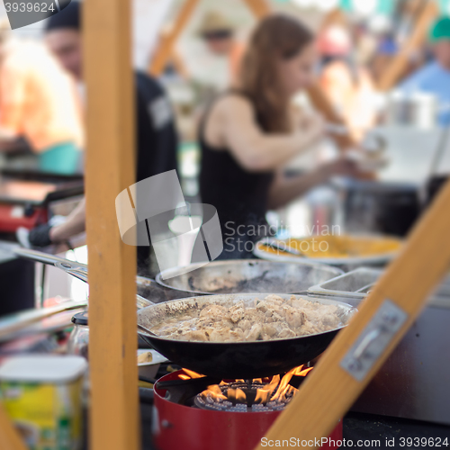 Image of Cheff cooking on outdoor street food festival.