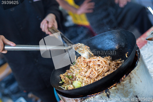 Image of Cheff cooking on outdoor street food festival.