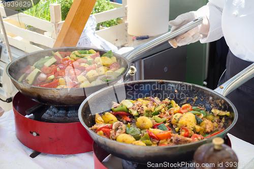 Image of Cheff cooking on outdoor street food festival.