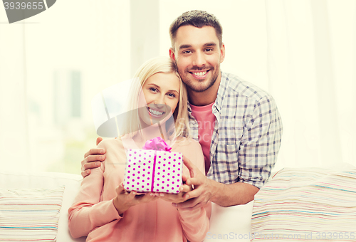 Image of happy man giving woman gift box at home