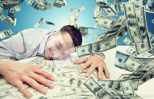 Image of happy businessman with heap of money