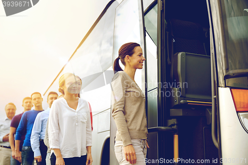 Image of group of happy passengers boarding travel bus