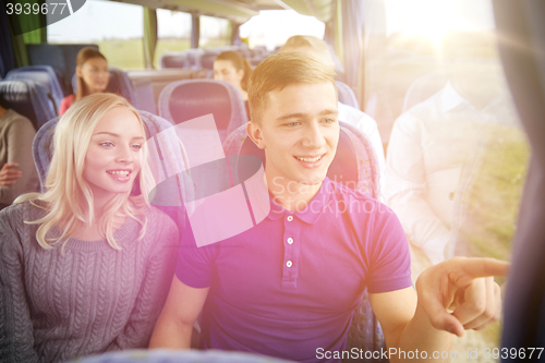 Image of happy teenage couple or passengers in travel bus