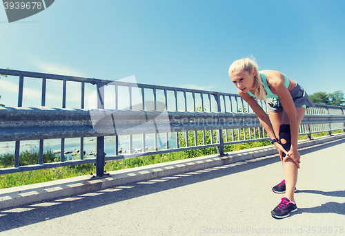 Image of young woman with injured knee or leg outdoors