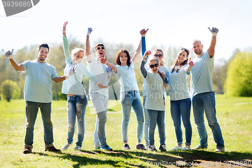 Image of group of volunteers showing thumbs up in park