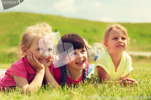 Image of group of kids lying on blanket or cover outdoors