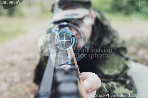 Image of close up of soldier or sniper with gun in forest