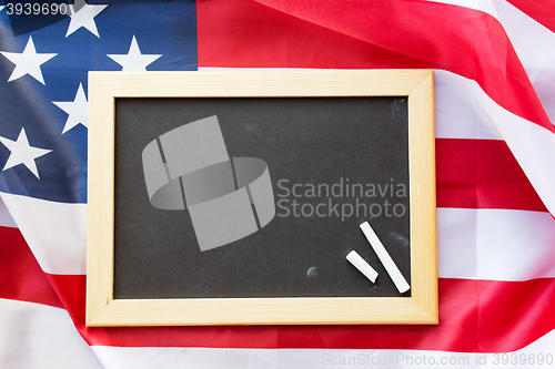 Image of close up of school blackboard on american flag