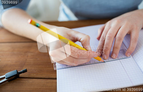 Image of close up of hands with ruler and pencil drawing 