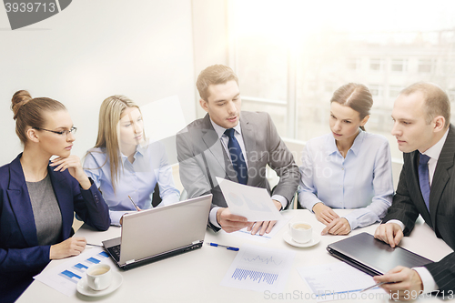 Image of business team with laptop having discussion