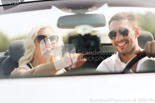 Image of happy couple usin gps navigation system in car