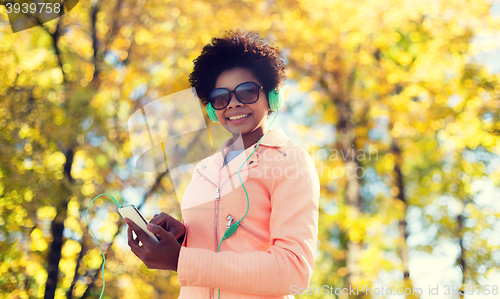 Image of happy young woman with smartphone and headphones
