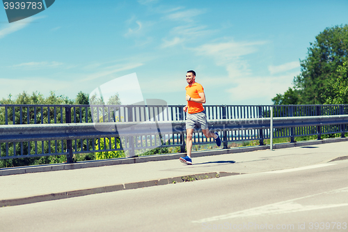 Image of smiling young man running at summer seaside