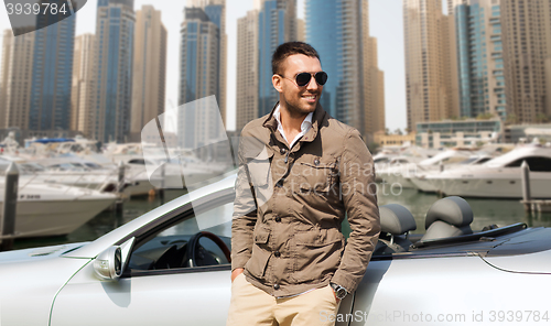 Image of happy man near cabriolet car on city 