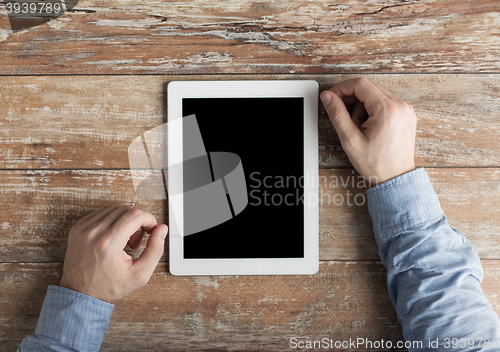 Image of close up of male hands to tablet pc on table