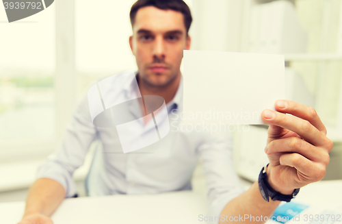 Image of close up of businessman with blank paper at office