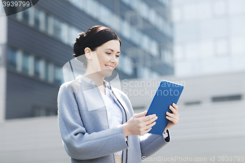 Image of smiling business woman with tablet pc in city
