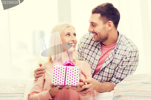 Image of happy man giving woman gift box at home