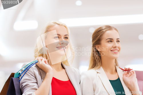 Image of happy young women with shopping bags in mall