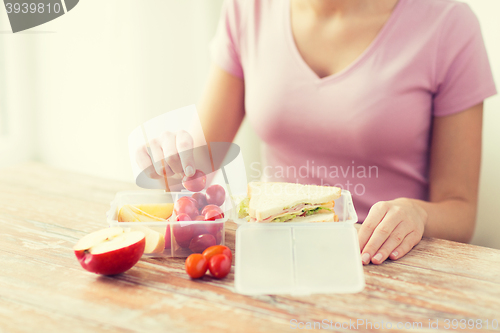 Image of close up of woman with food in plastic container