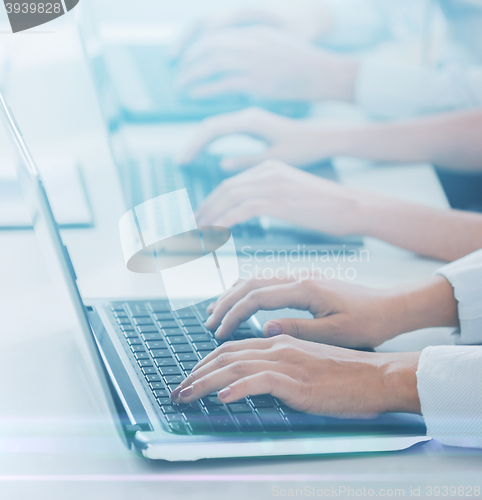 Image of group of people working with laptops in office