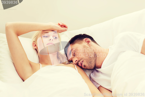 Image of couple sleeping in bed at home