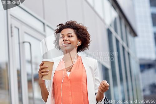 Image of happy african businesswoman with coffee in city