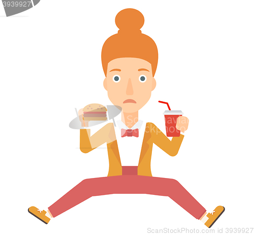 Image of Woman eating hamburger. 