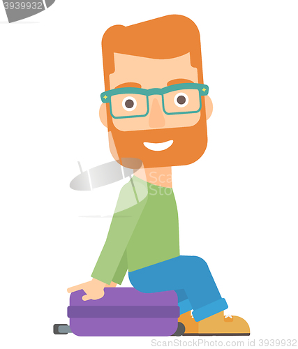 Image of Man sitting on his suitcase.