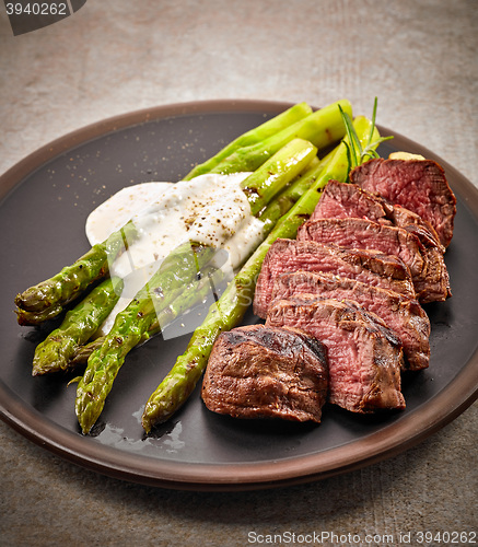 Image of portion of sliced beef steak and asparagus