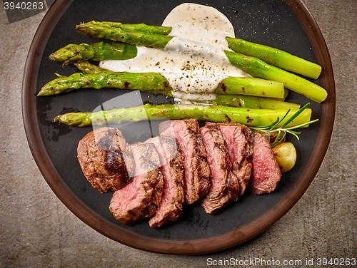 Image of portion of sliced beef steak and asparagus