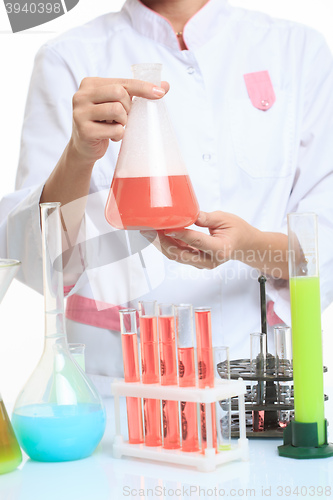 Image of hands holding test tubes with chemical elements. 