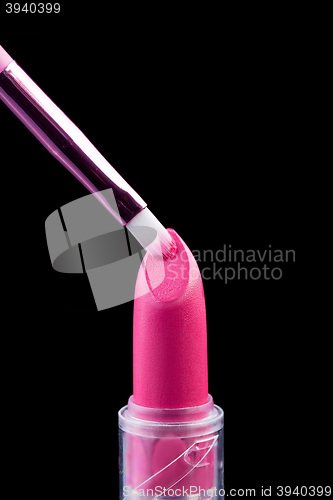 Image of Tube of lipstick with a brush make-up on black 