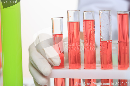 Image of hands holding test tubes with chemical elements. 