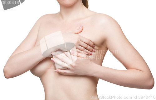 Image of Examining breasts. Close-up of young shirtless woman examining her breasts while. Isolated white background