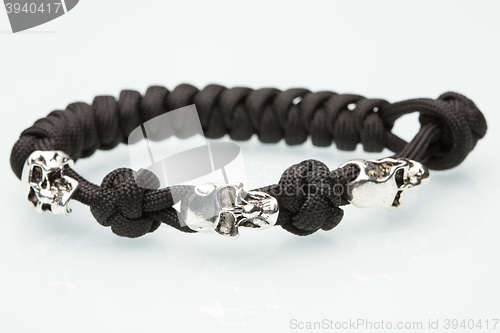 Image of Black braided bracelet with skulls on white background