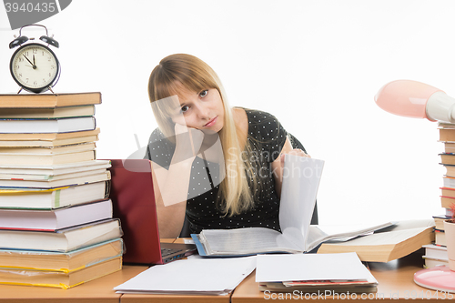 Image of Student paper dull leafs at a table among books and stacks of looks in the picture
