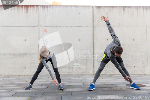 Image of close up of couple stretching on city street