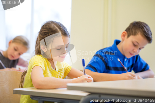 Image of group of school kids writing test in classroom