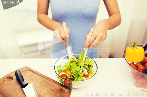 Image of close up of woman cooking vegetable salad at home