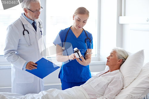 Image of doctor giving medicine to senior woman at hospital